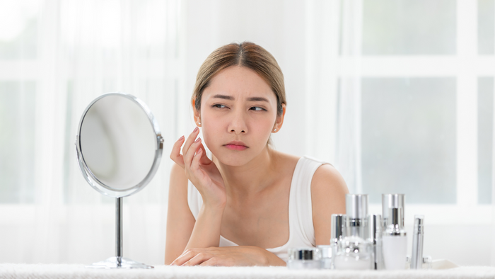 a woman looking confused with too many skincare products